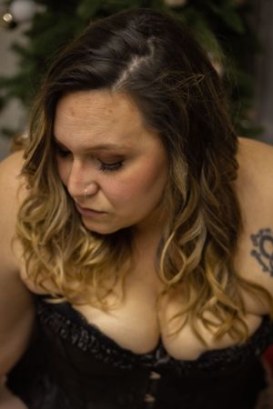Intimate portrait with soft lighting and Christmas decor in background.