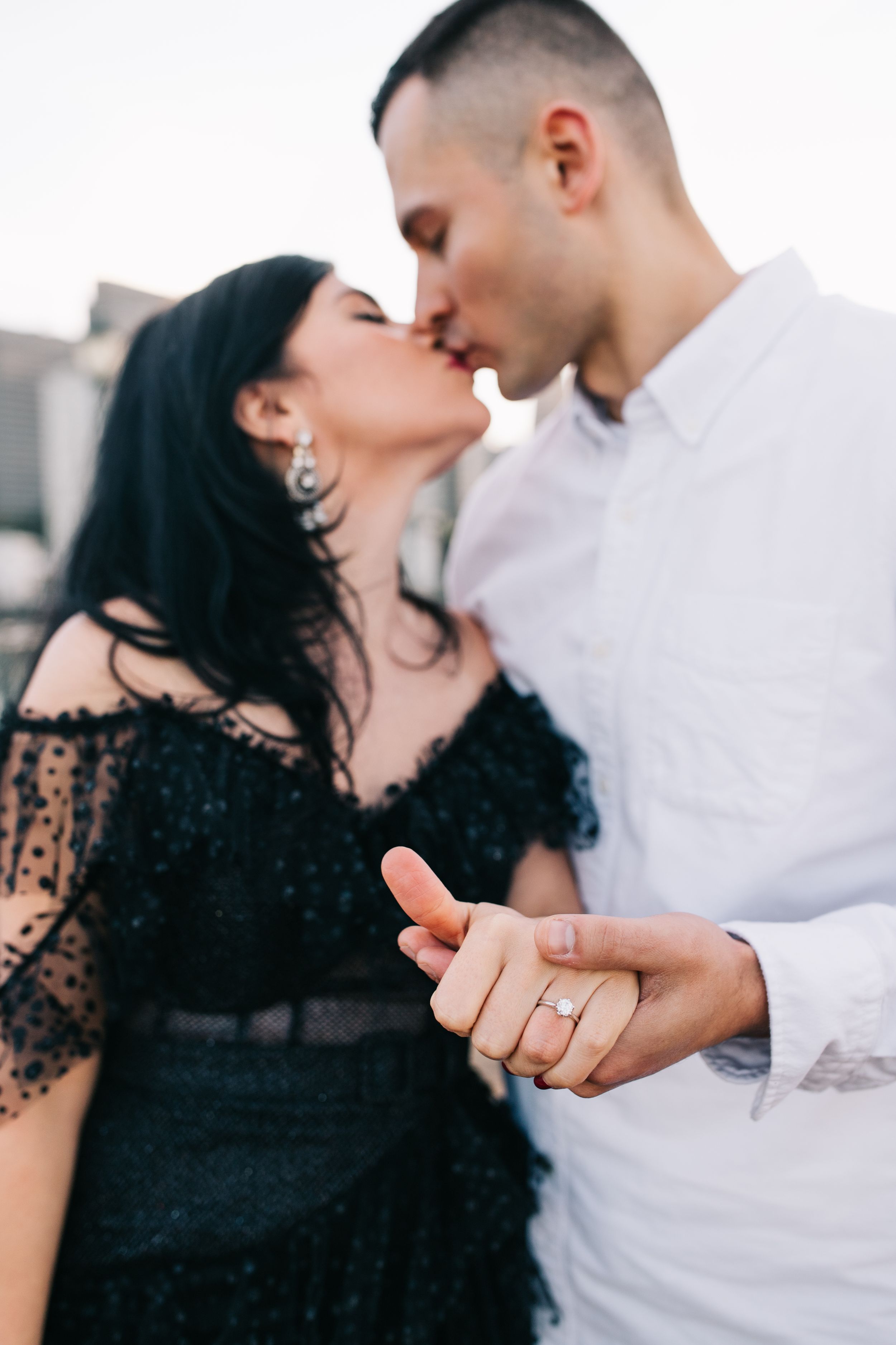 An intimate moment captured between a couple in contrasting black and white formal wear.