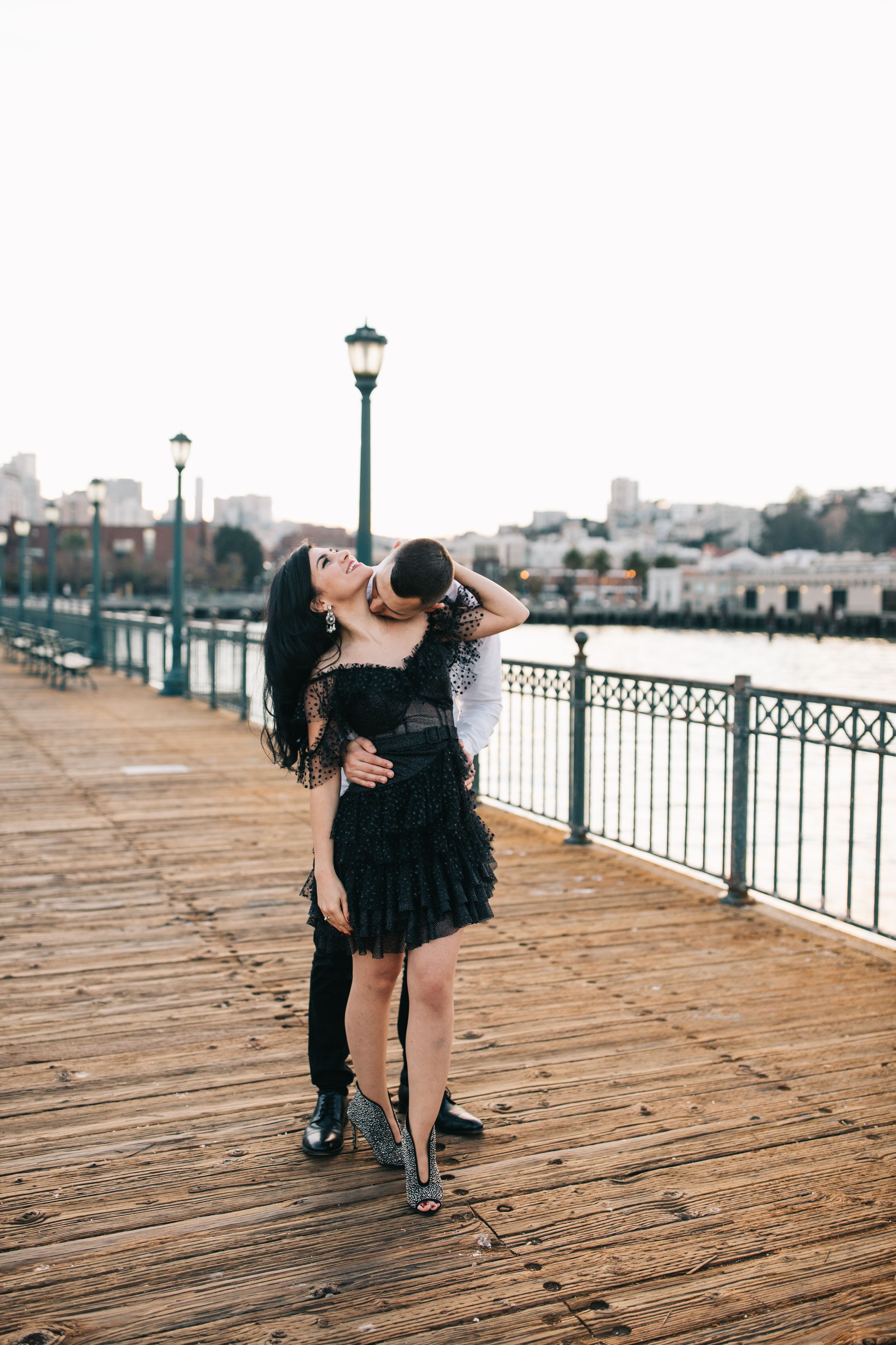 A romantic pose on a pier with the San Francisco waterfront creating a perfect backdrop.