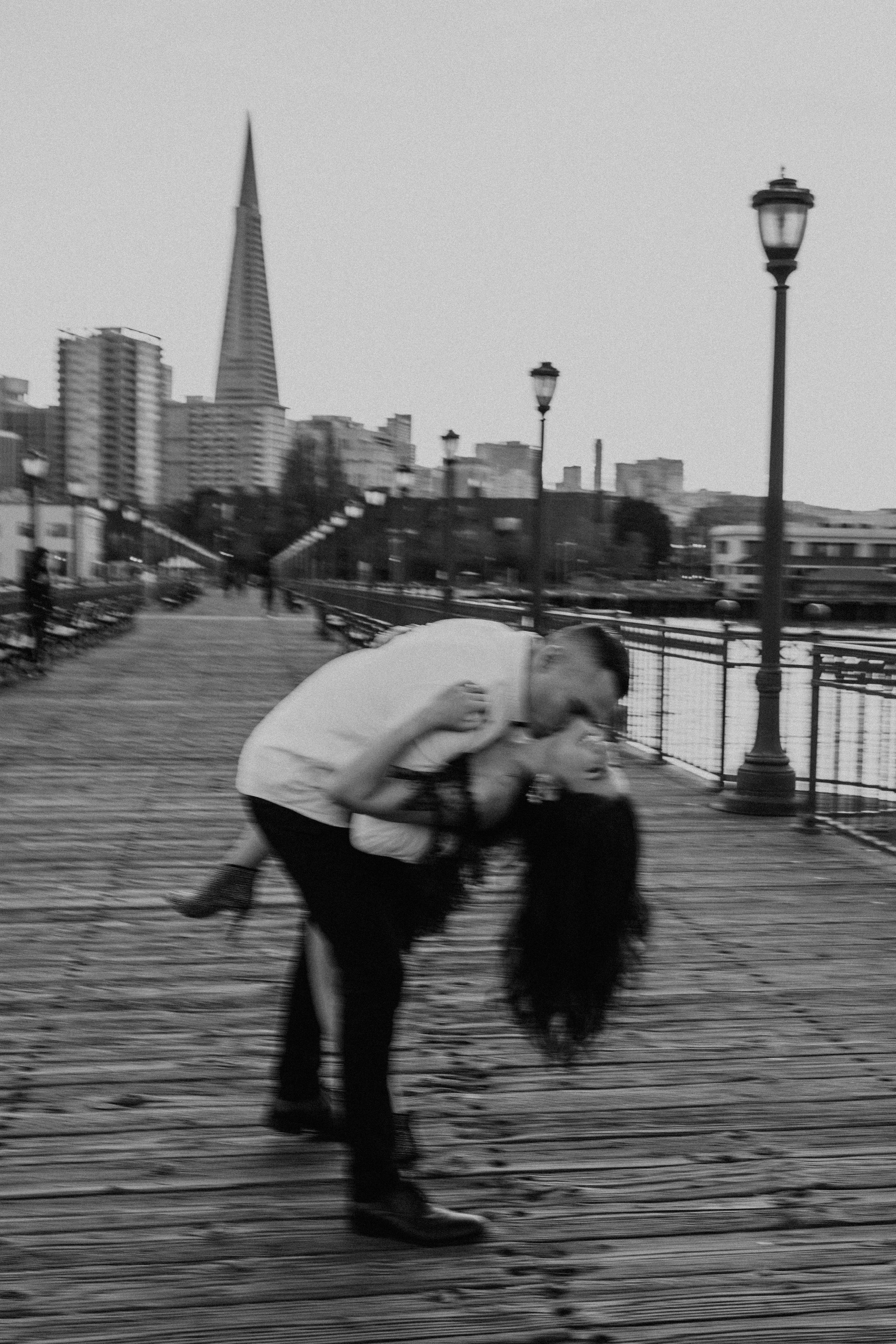 A dramatic black and white photo on a pier with the Transamerica Pyramid visible in the distance.