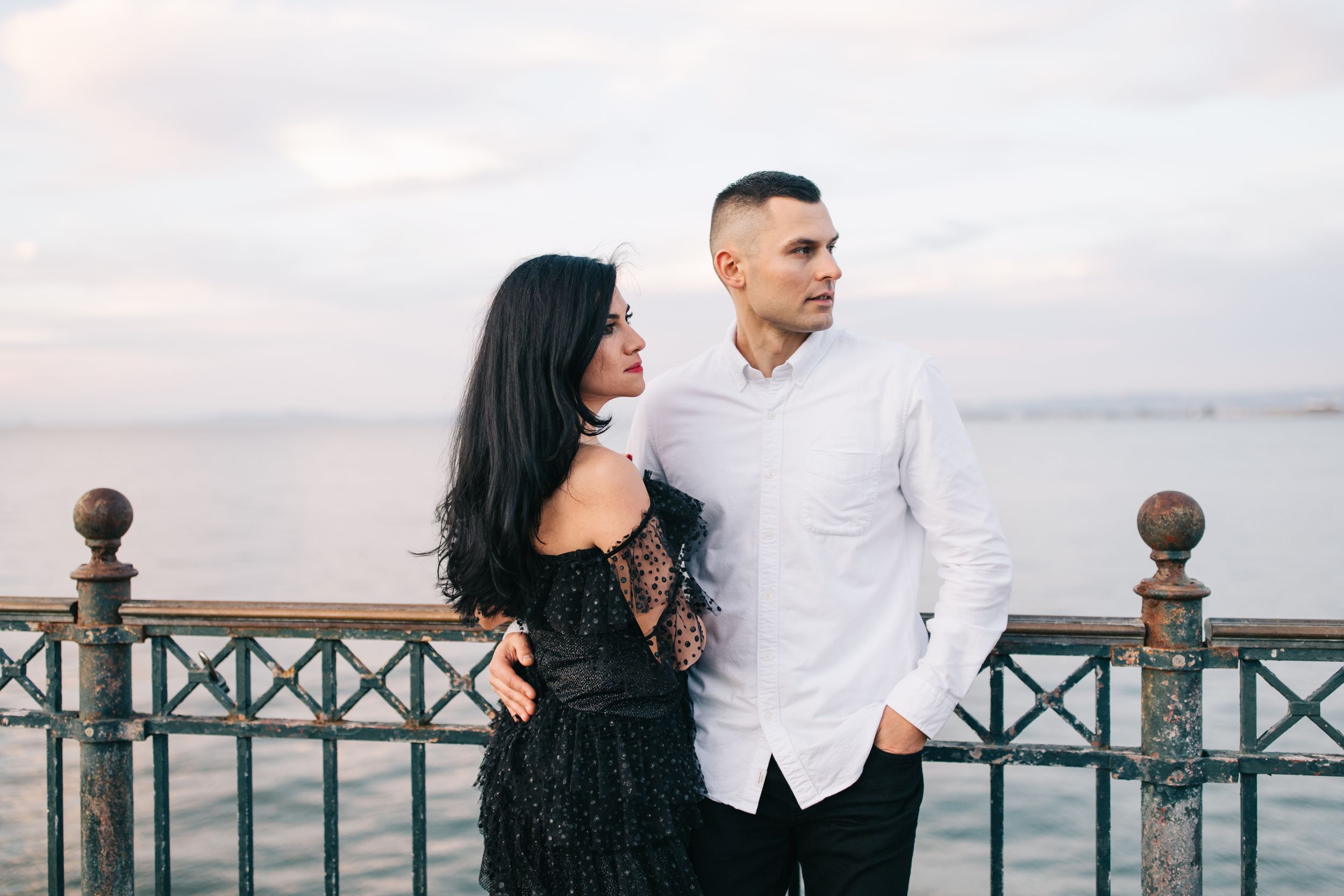 A stylish couple posing against the San Francisco Bay with dramatic evening light.