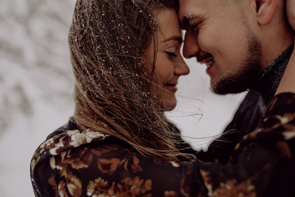 An intimate close-up of a couple sharing a tender moment in the snow.