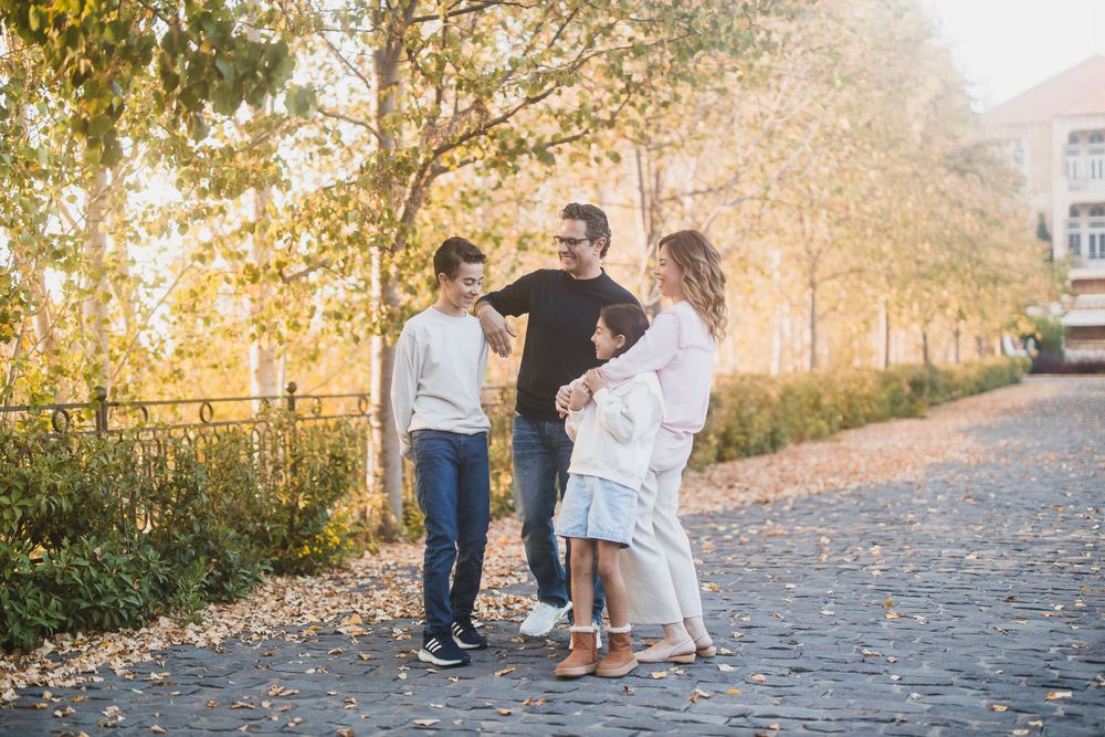 Casual group photo on a tree-lined pathway during golden hour in fall.