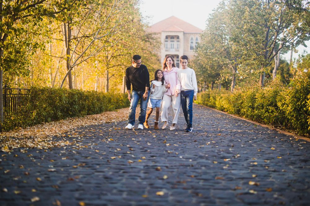 A group walks together down a scenic pathway lined with fall foliage.