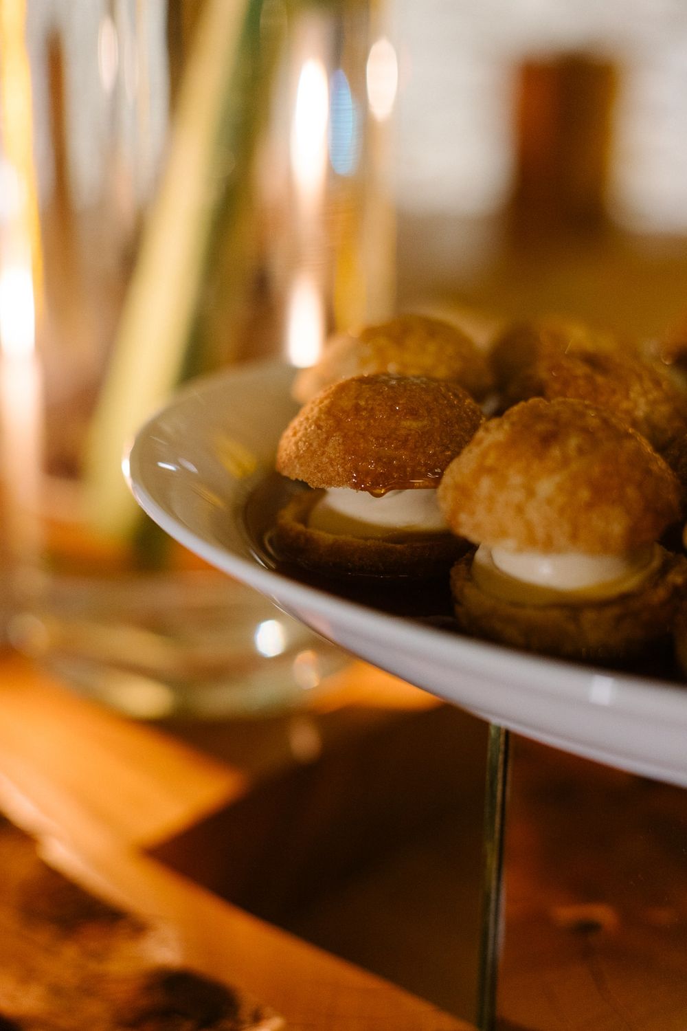Cream-filled pastry puffs displayed on an elegant white serving plate.