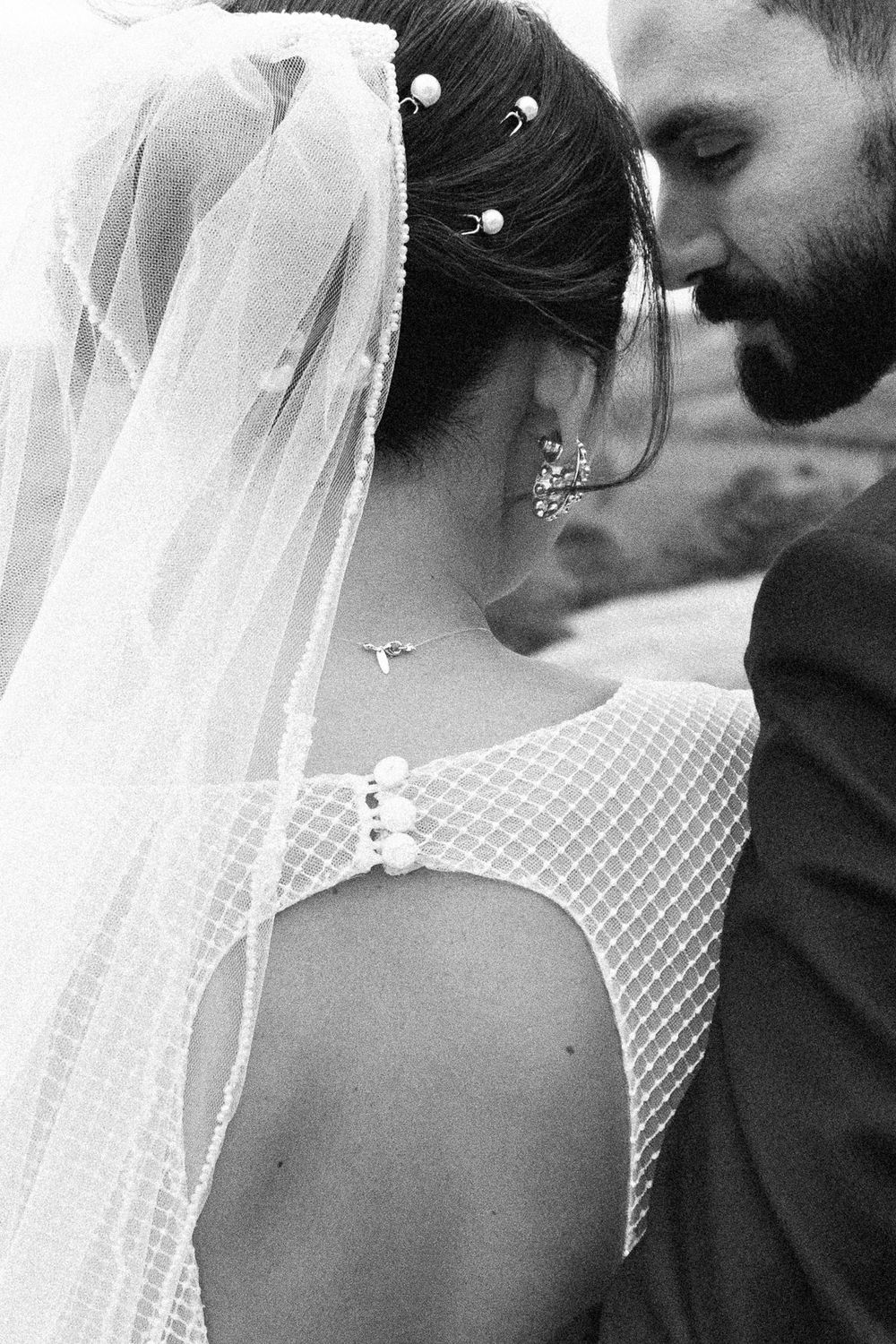 Close-up detail of a bride's veil and lace dress with delicate pearl accents.