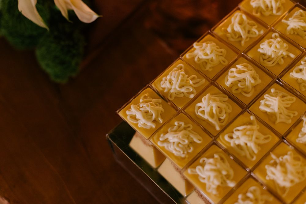 Close-up view of golden chocolate squares arranged in neat rows on a dark wooden surface.