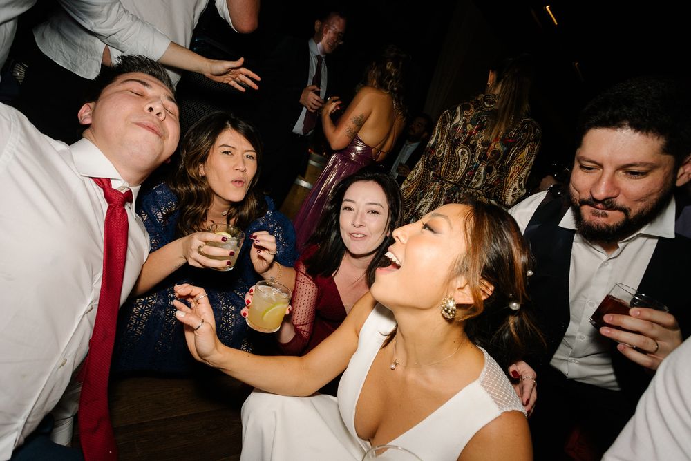 Energetic wedding reception party scene with guests dancing and celebrating.