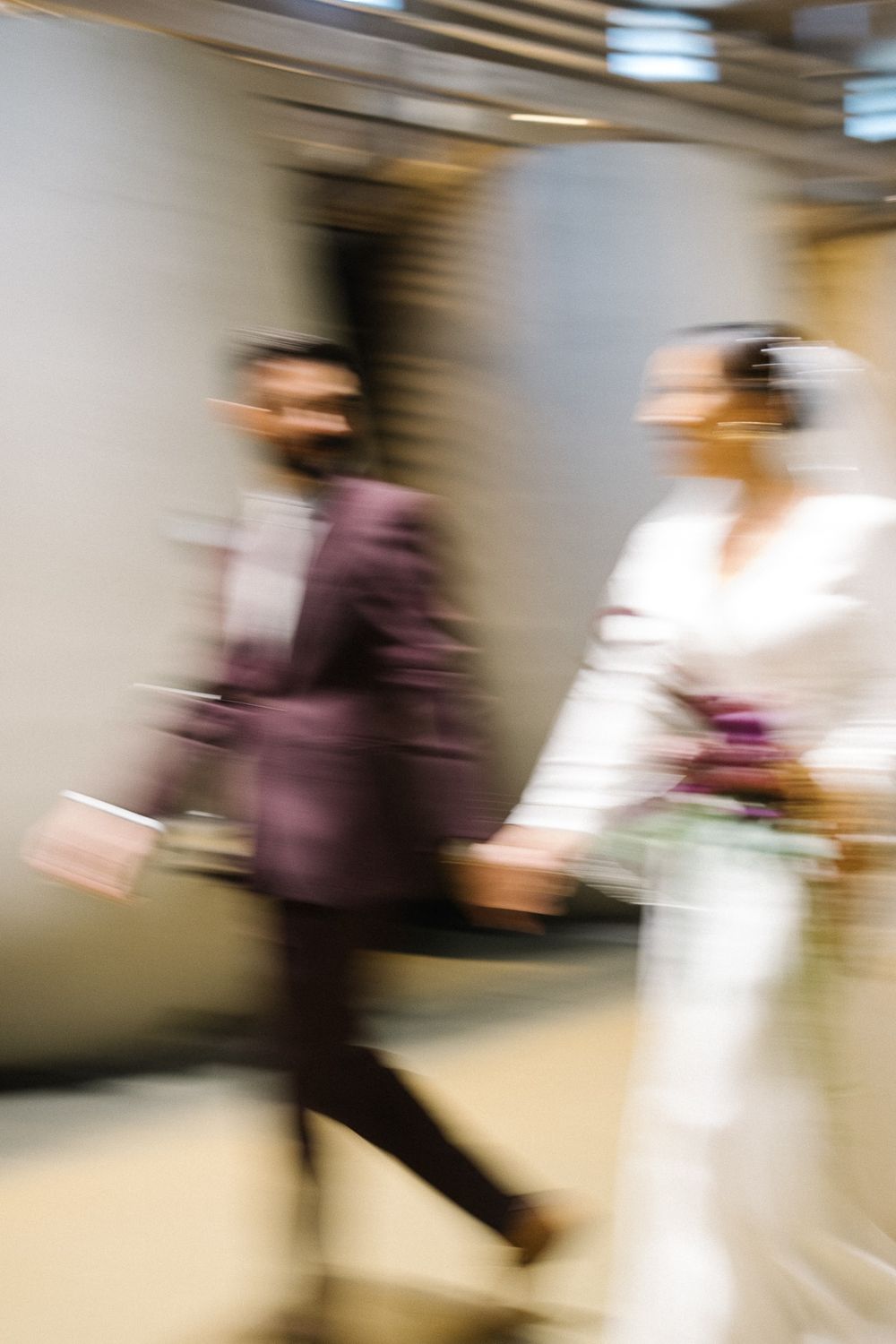 Artistic motion blur of couple walking in formal wedding attire.