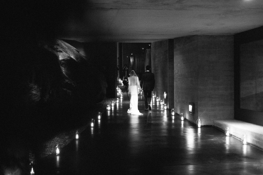 Moody corridor lined with glowing candles creating a dramatic wedding atmosphere.