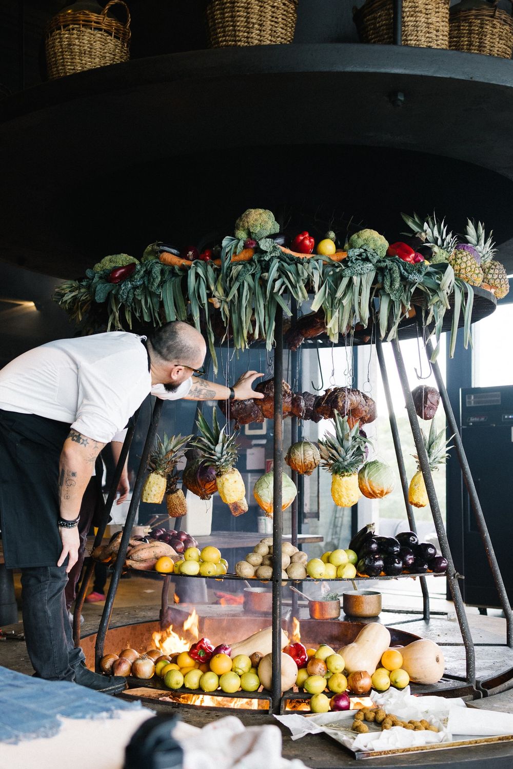 Fresh fruit and tropical produce displayed on tiered stand at wedding reception.