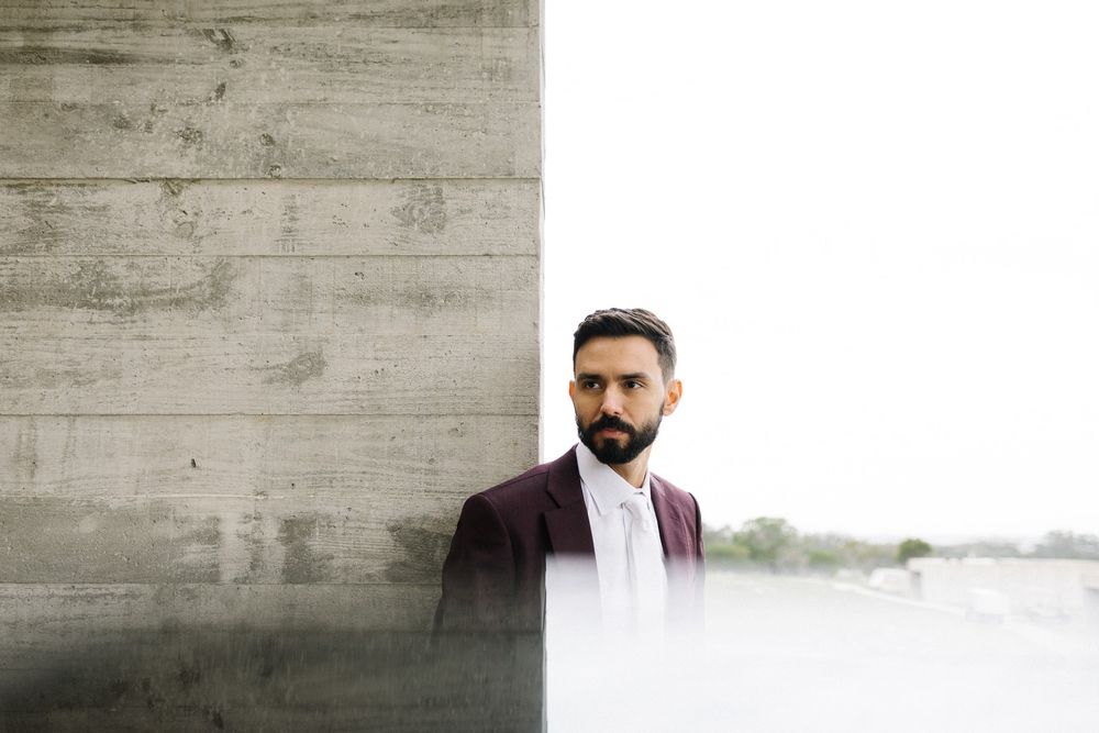 Stylish portrait against concrete wall with dramatic lighting and composition.