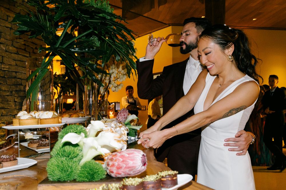 A couple cutting their wedding cake at an elegantly decorated reception venue.