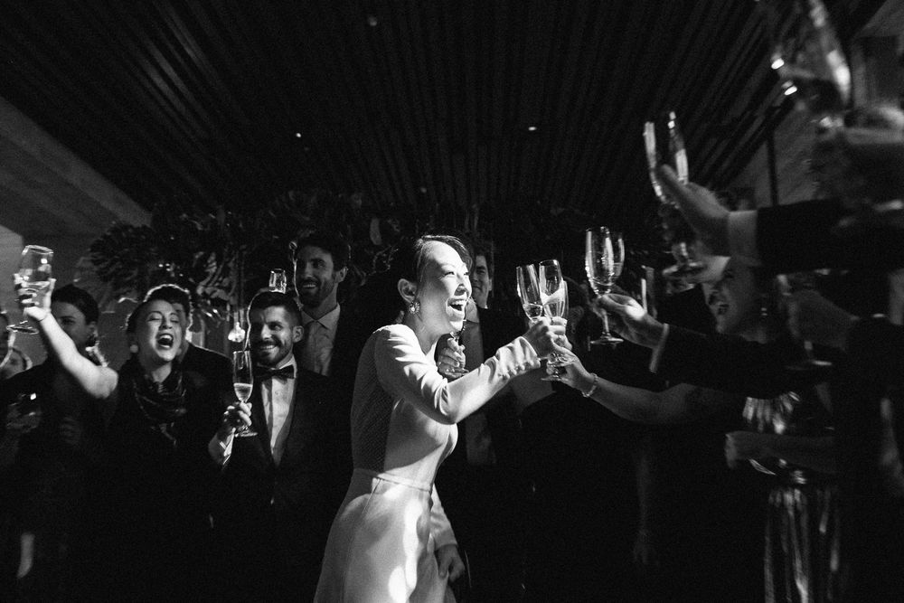 Black and white photo of energetic dancing and celebration at a wedding reception.