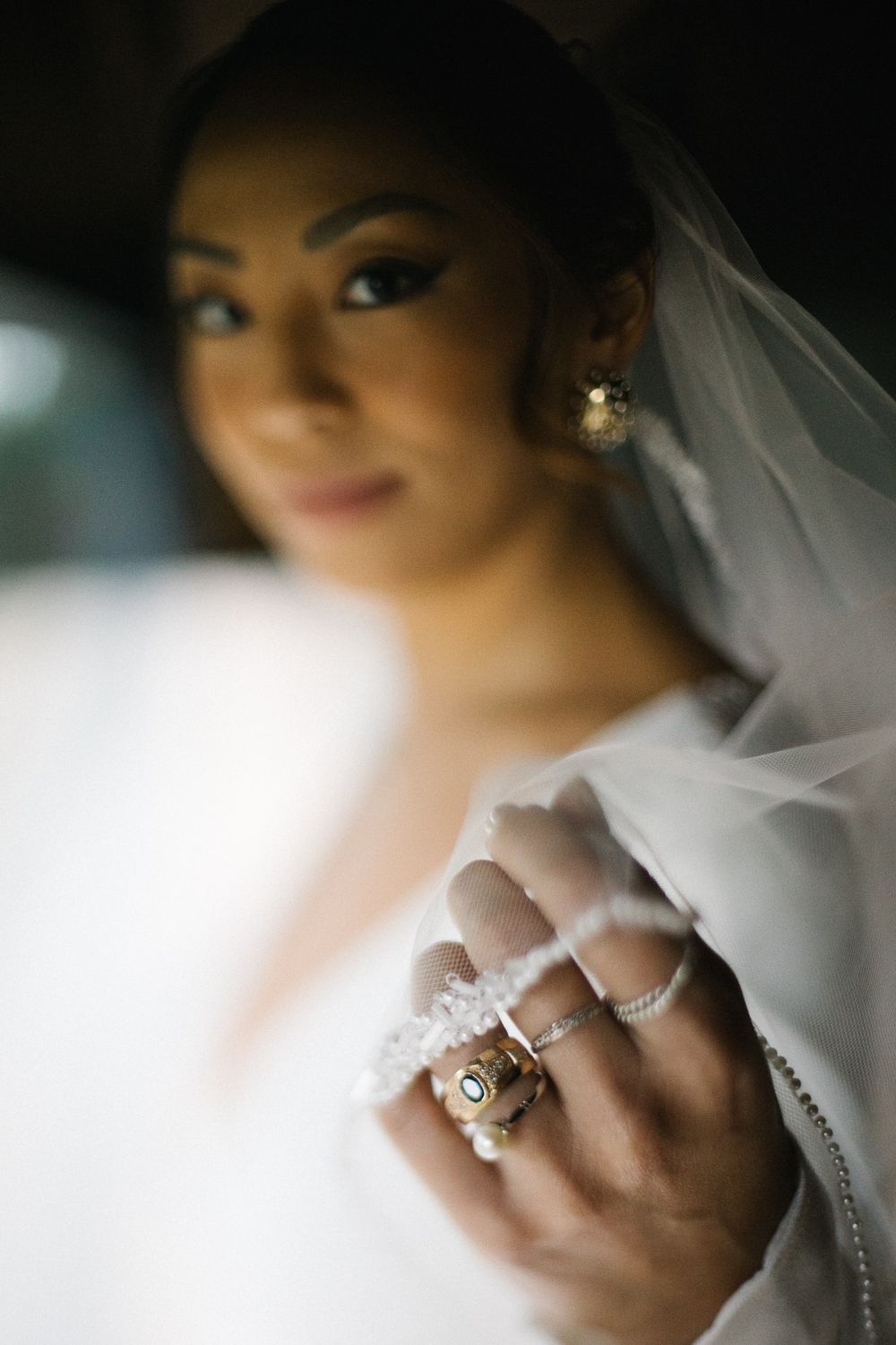 Close-up shot of bridal jewelry and delicate veil details.