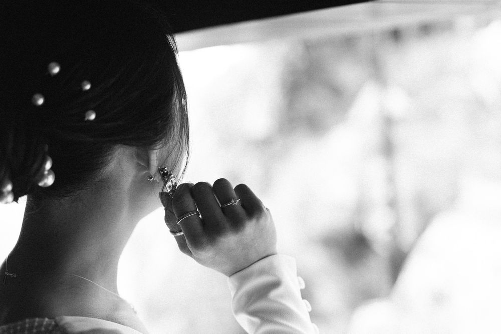 Black and white detail shot of a bridal hairstyle with hand raised.