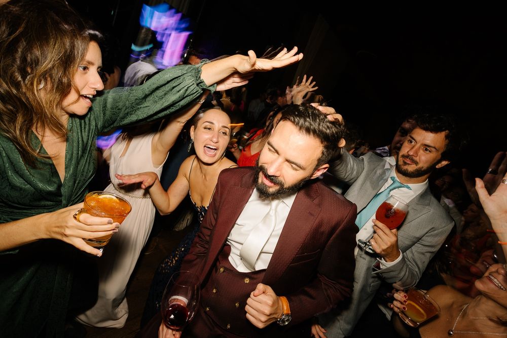 Energetic party scene with people dancing and celebrating in a dimly lit venue.