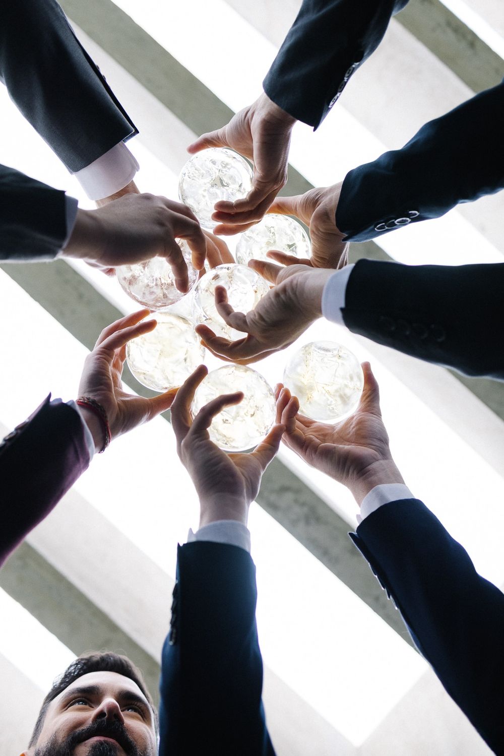 Creative overhead shot of hands forming a circle around glowing light.