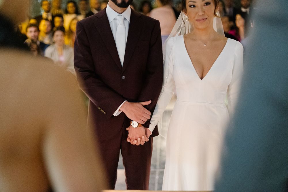 Intimate moment of couple holding hands during wedding ceremony.