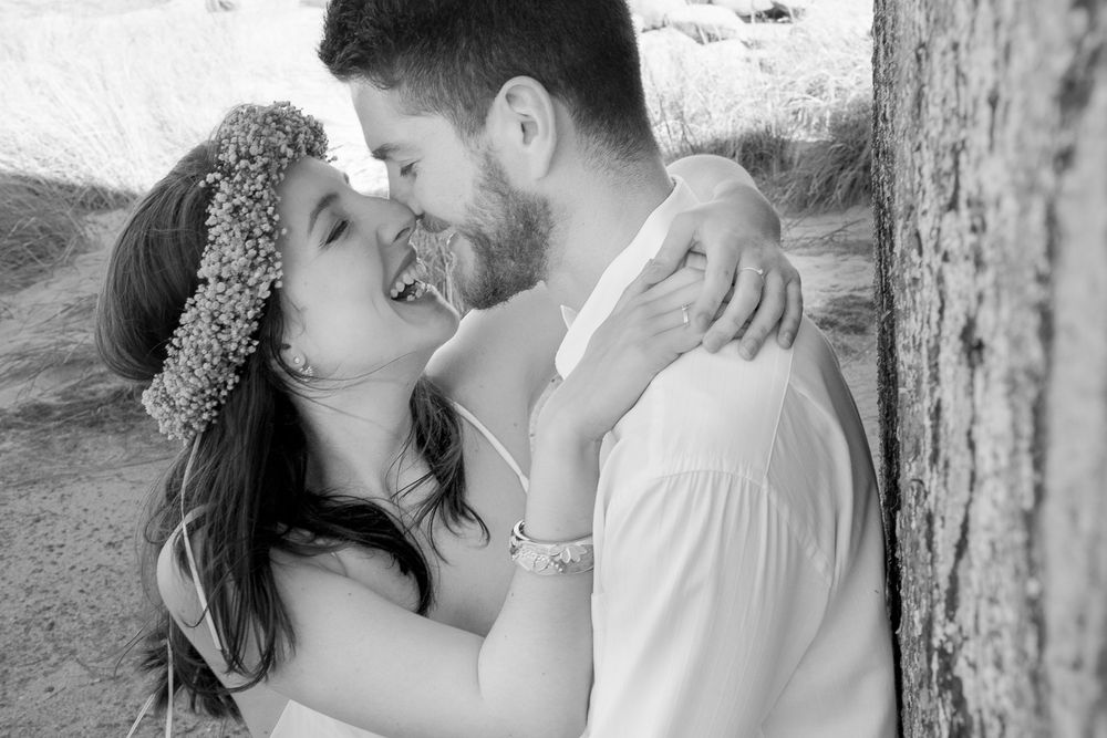 A tender embrace captured in black and white with floral crown details.