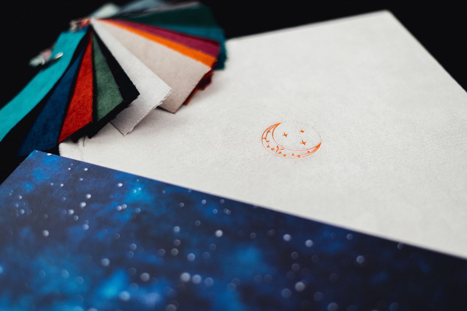 Photography packaging materials with teal and orange accents against a starry background.