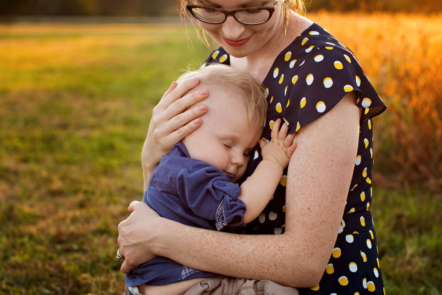 Mother cradling son whose eyes are closed