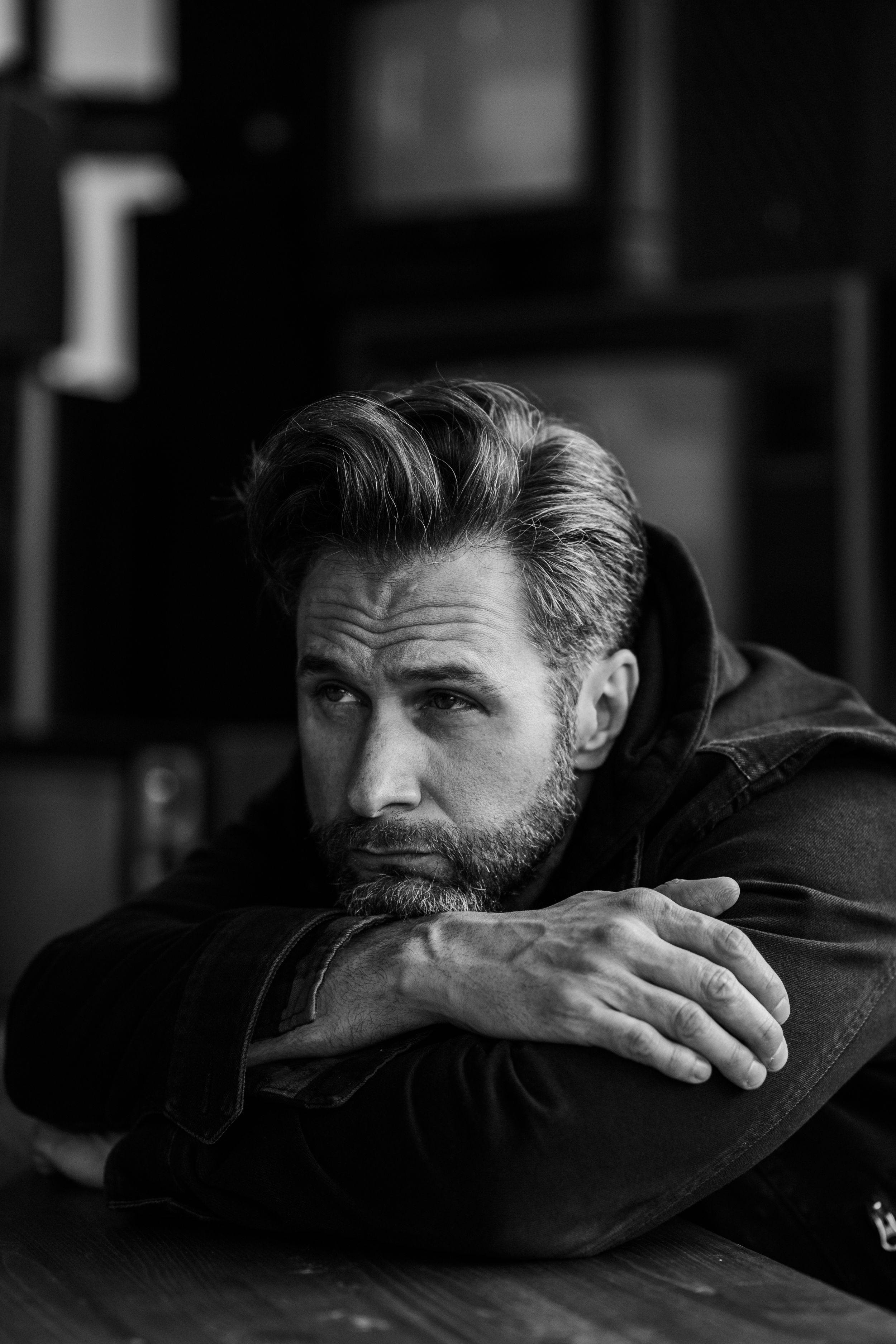 Black and white image of Actor Matt Wells leaning on his arms staring off camera