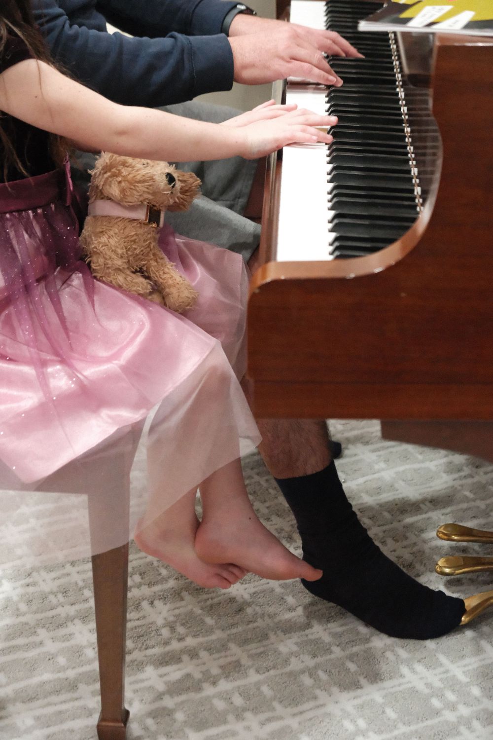 dad and daughter playing the piano together.