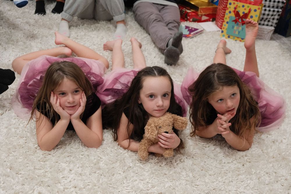 3 little girls in dresses laying on the floor taken with Fuji XT5 portra recipe.