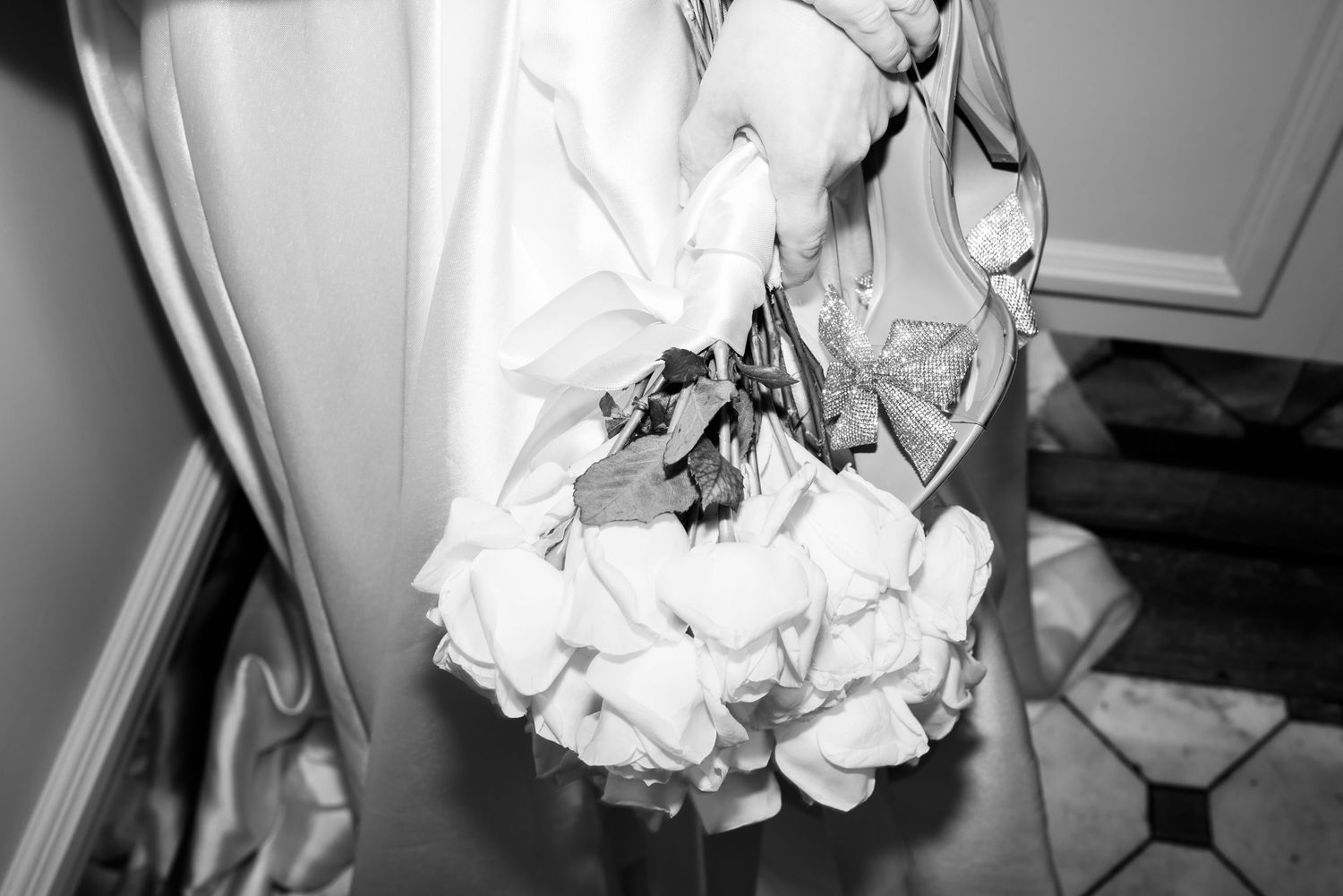 A close-up black and white detail shot of wedding dress ruffles and fabric.
