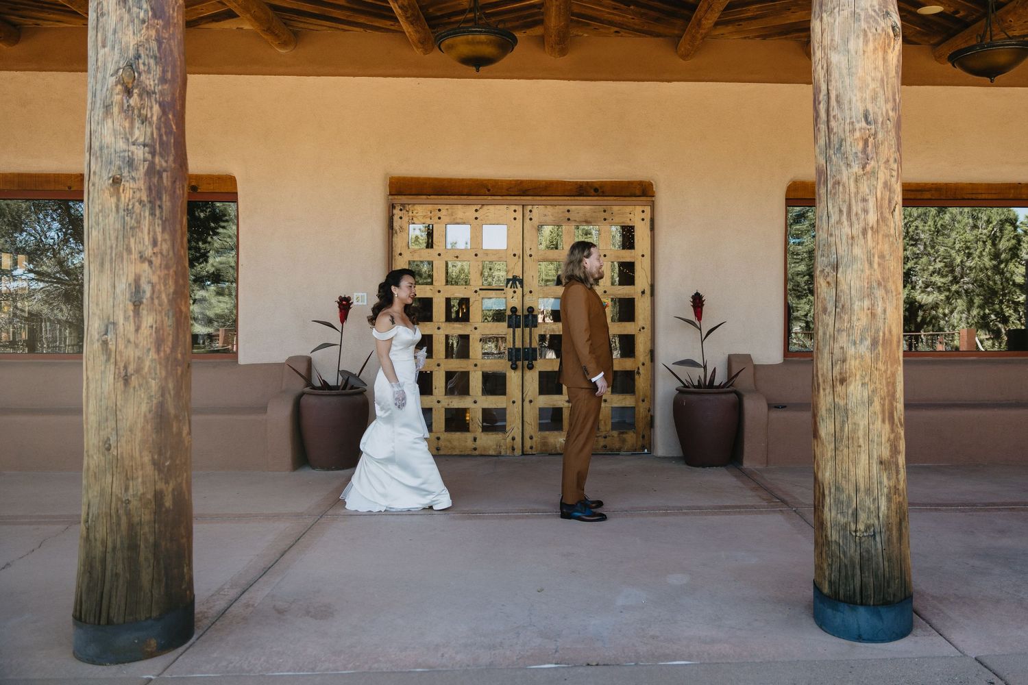 Bride and groom share first look moment at rustic Southwest wedding venue entrance.