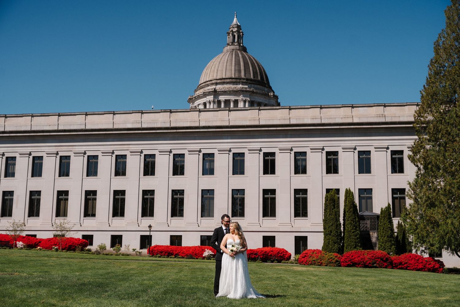 Mikayla and Ryan stand in an embrace outside the Olympia Courthouse for their Courthouse Wedding