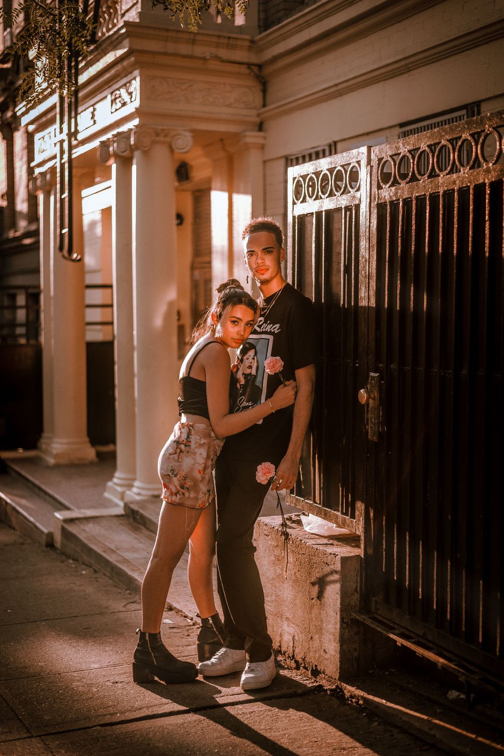 A romantic evening street scene of a couple embracing against an ornate building facade.