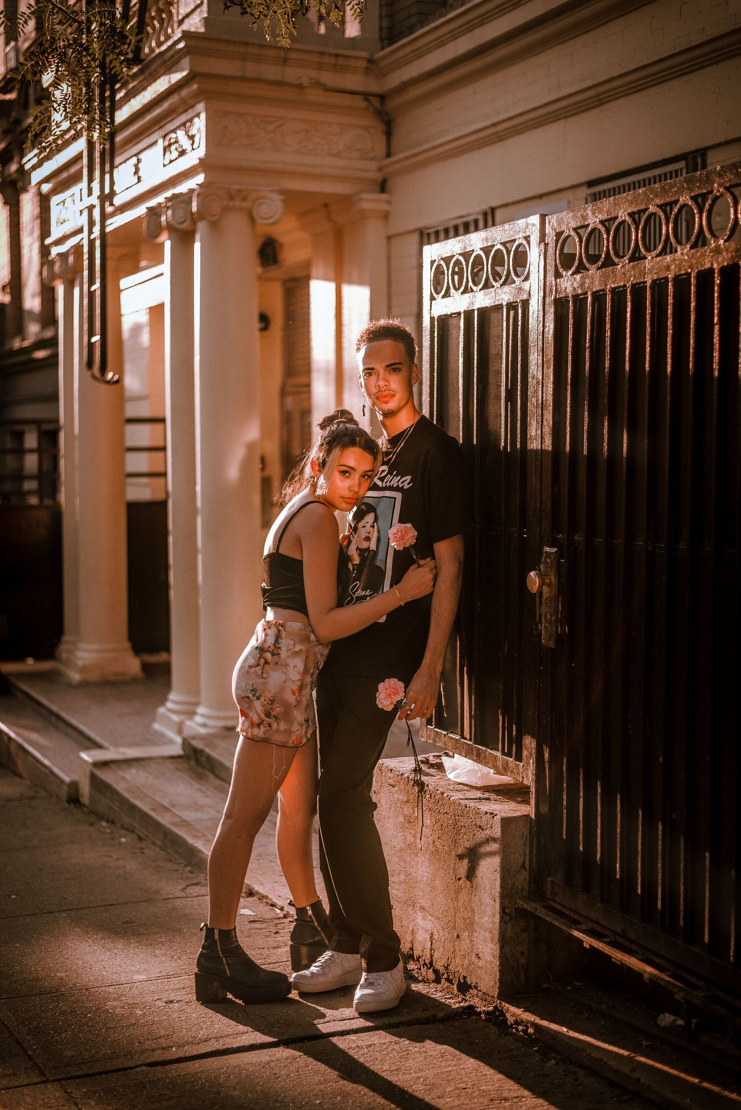 A romantic evening street scene of a couple embracing against an ornate building facade.