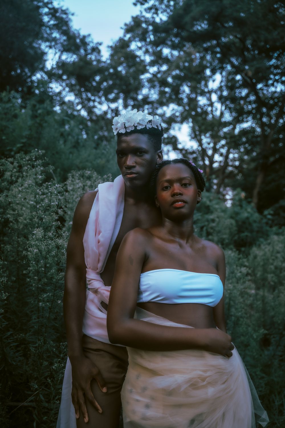 An ethereal forest portrait of two people in light-colored clothing creating a dreamy atmosphere.