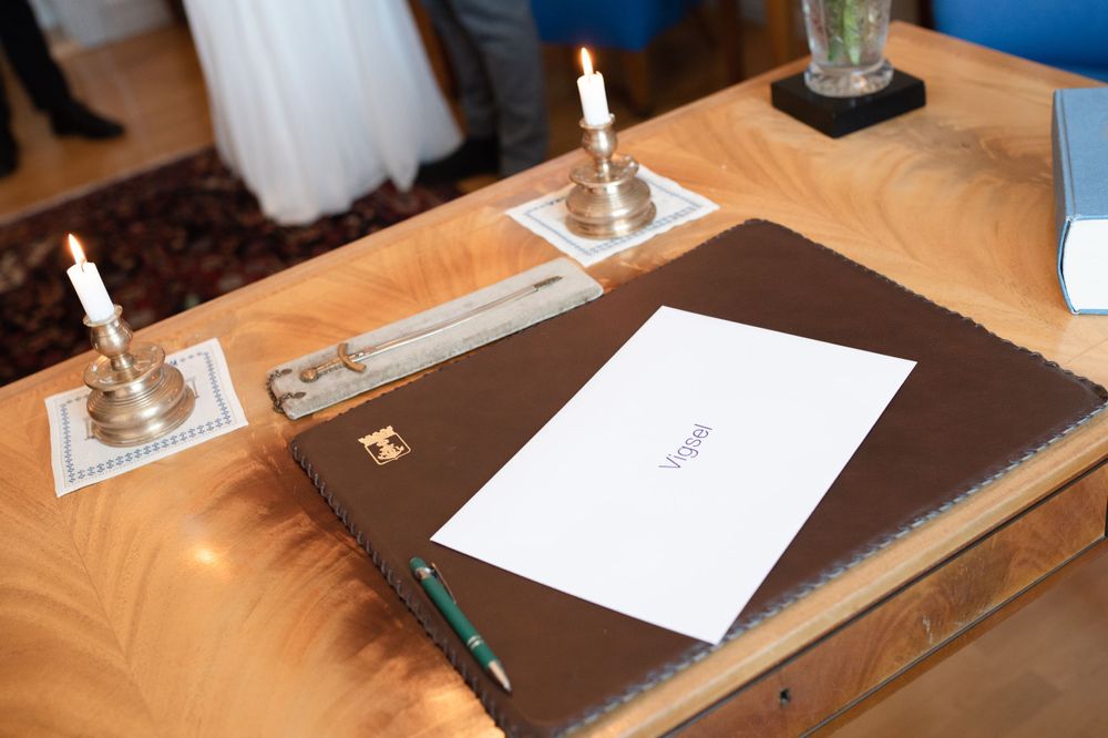 A formal document with candles on a wooden desk during a wedding ceremony.