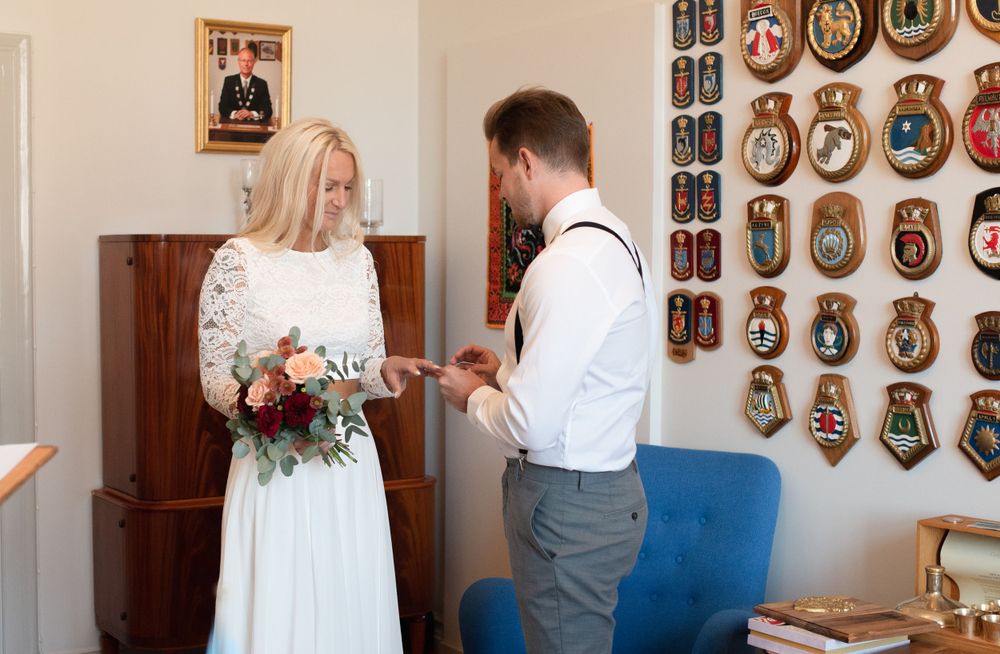 Couple sharing an intimate moment in a room decorated with vintage wall art during their wedding ceremony.