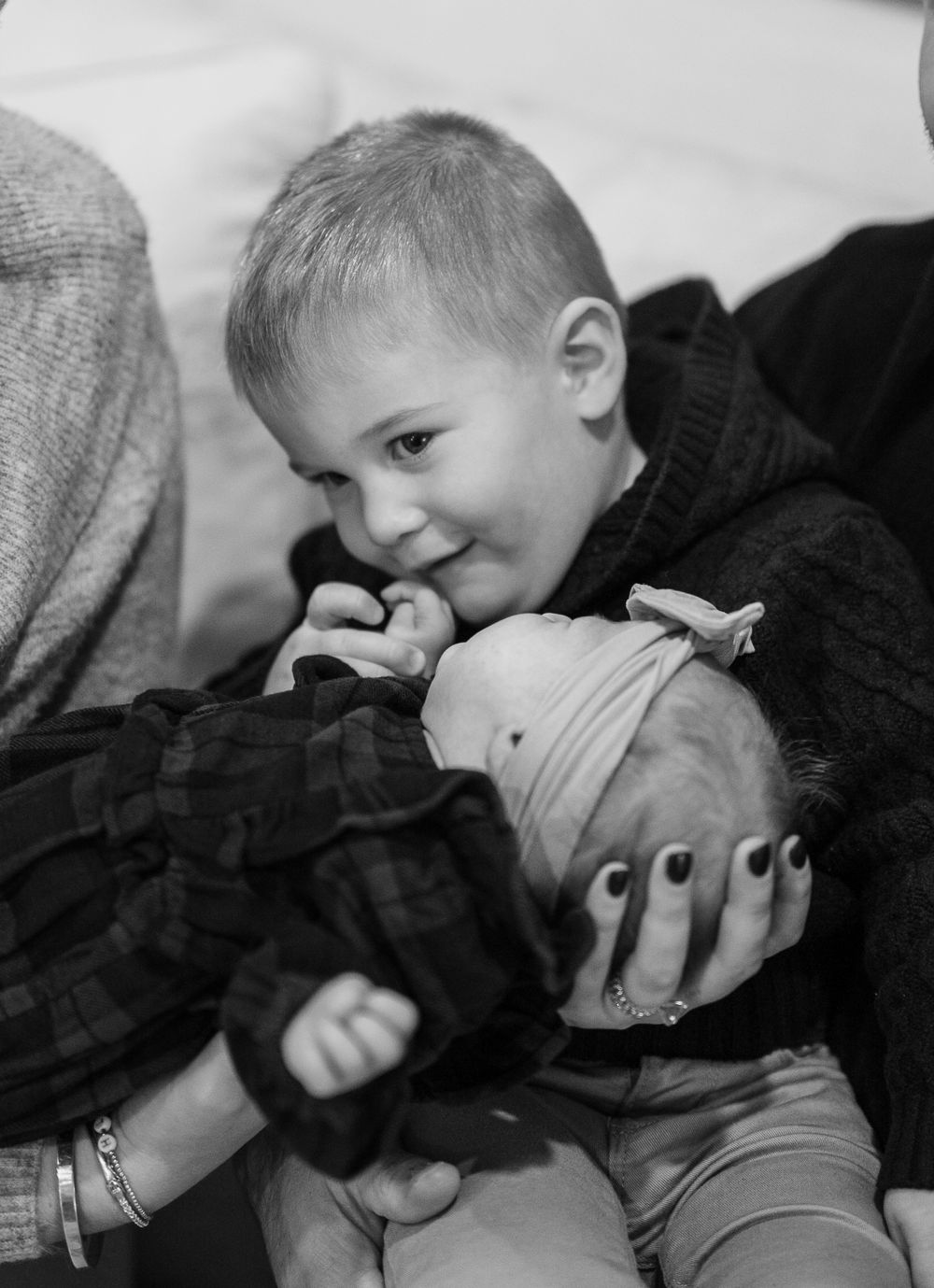 Child gently kissing and showing affection in black and white photo series.