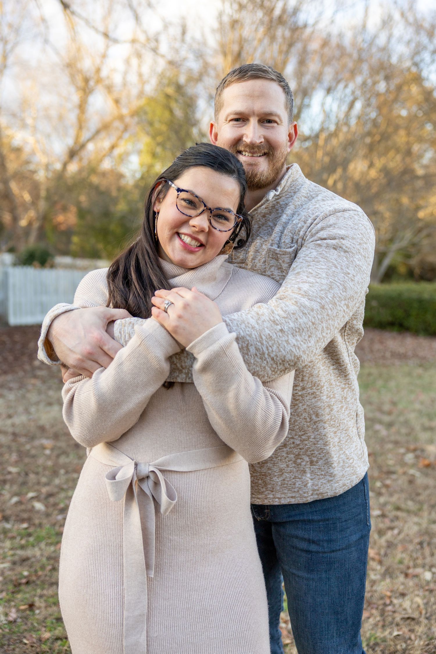 A couple stands together at the Historic Oak View Park in Raleigh, NC.