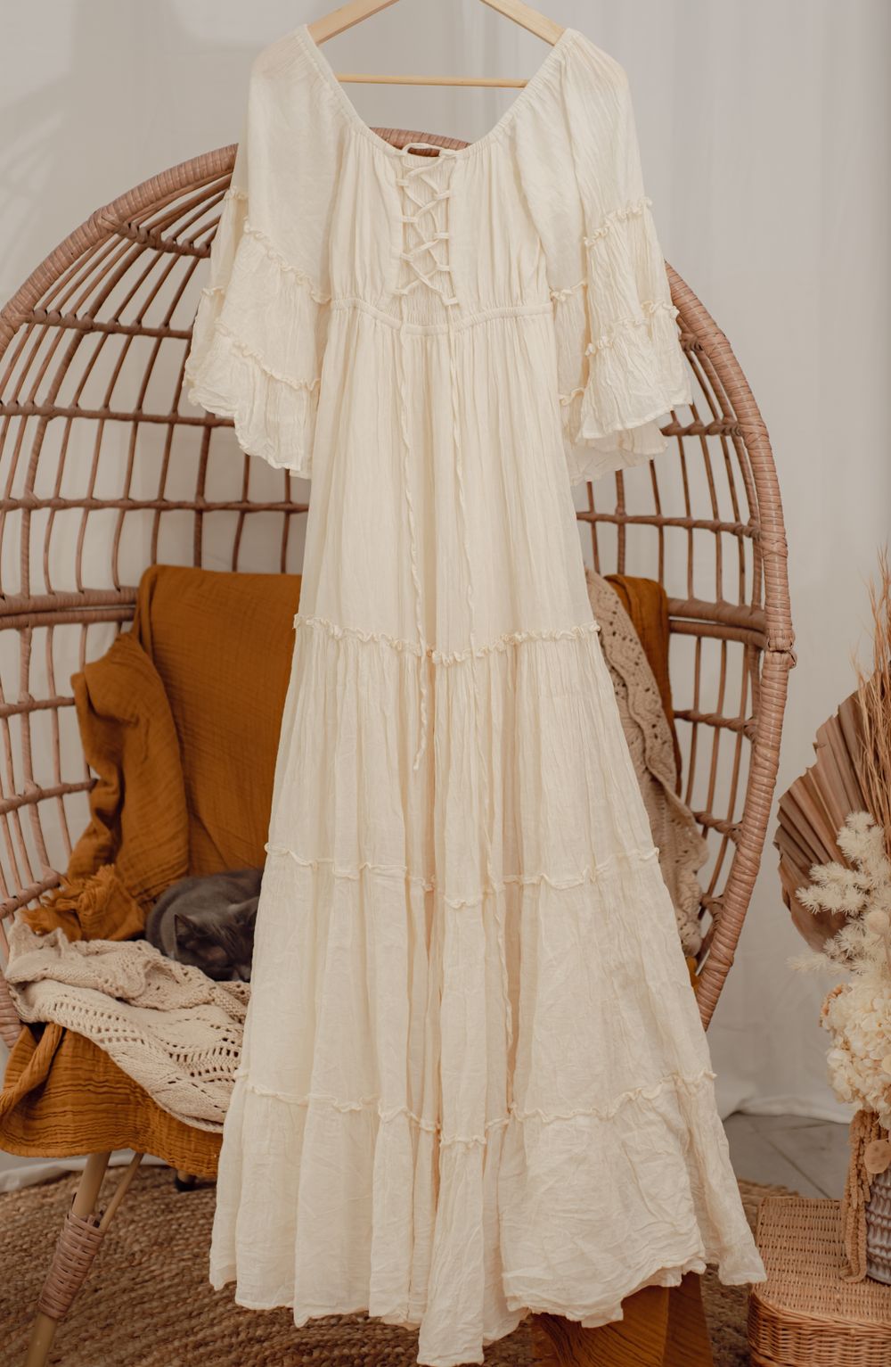 A vintage-inspired white cotton maxi dress with tiered ruffles on display.