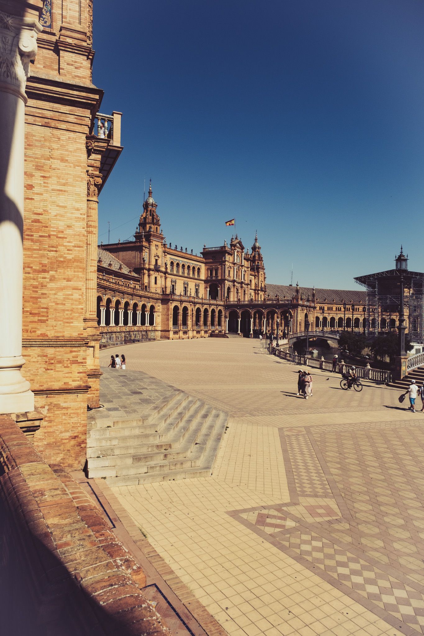 Wide angle view of Plaza de Espana Seville Spain showing ornate tiled plaza and curved colonnaded building.