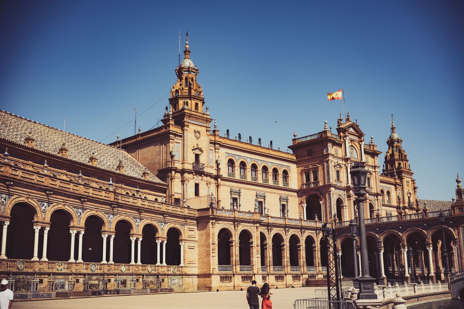 Plaza de Espana Seville Spain ornate Renaissance baroque building with arched colonnade under clear blue sky.