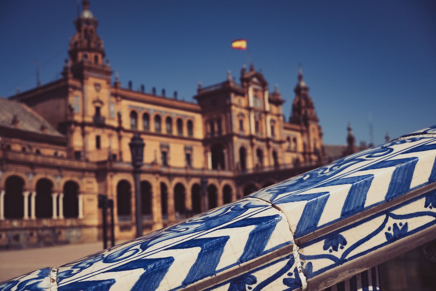 Close-up of blue and white decorative ceramic tile railing at Plaza de España, Seville, Spain.