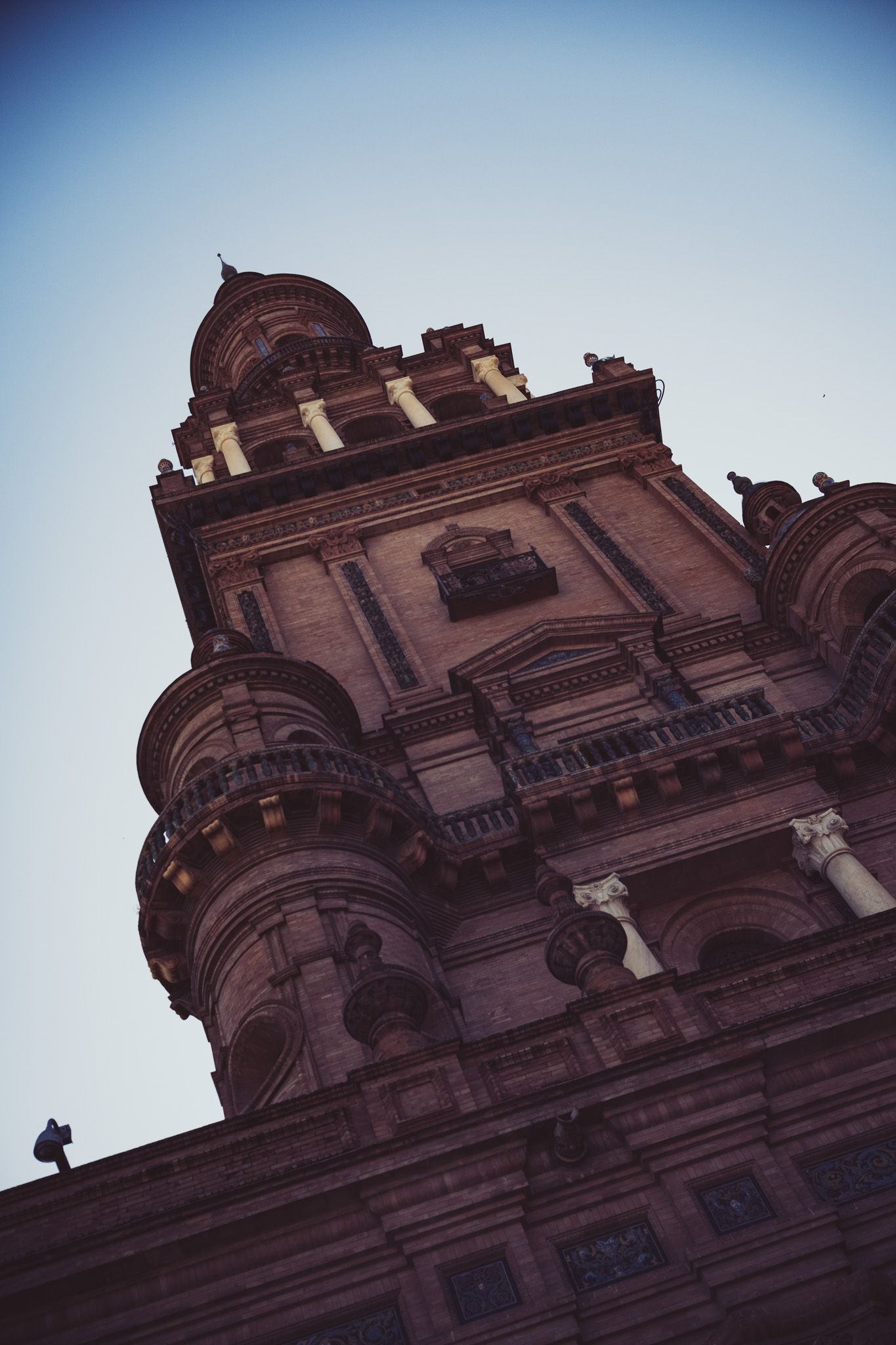 Low angle view of ornate baroque tower at Plaza de España against clear blue sky in Seville, Spain.