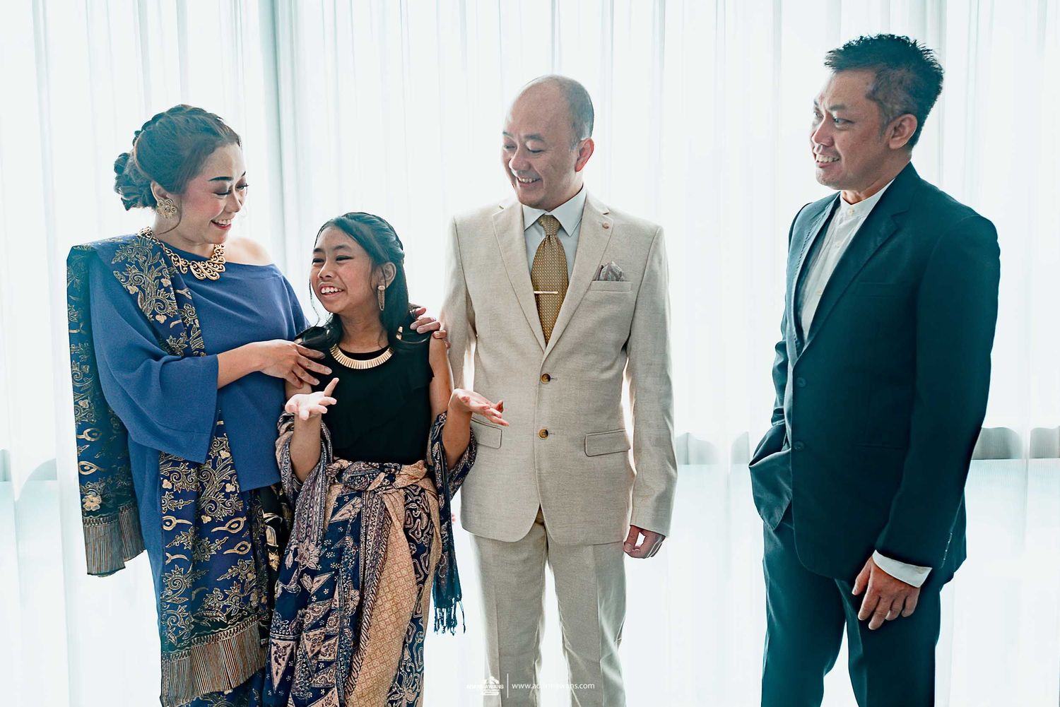 Family gathering before wedding ceremony in elegant blue and beige formal attire.