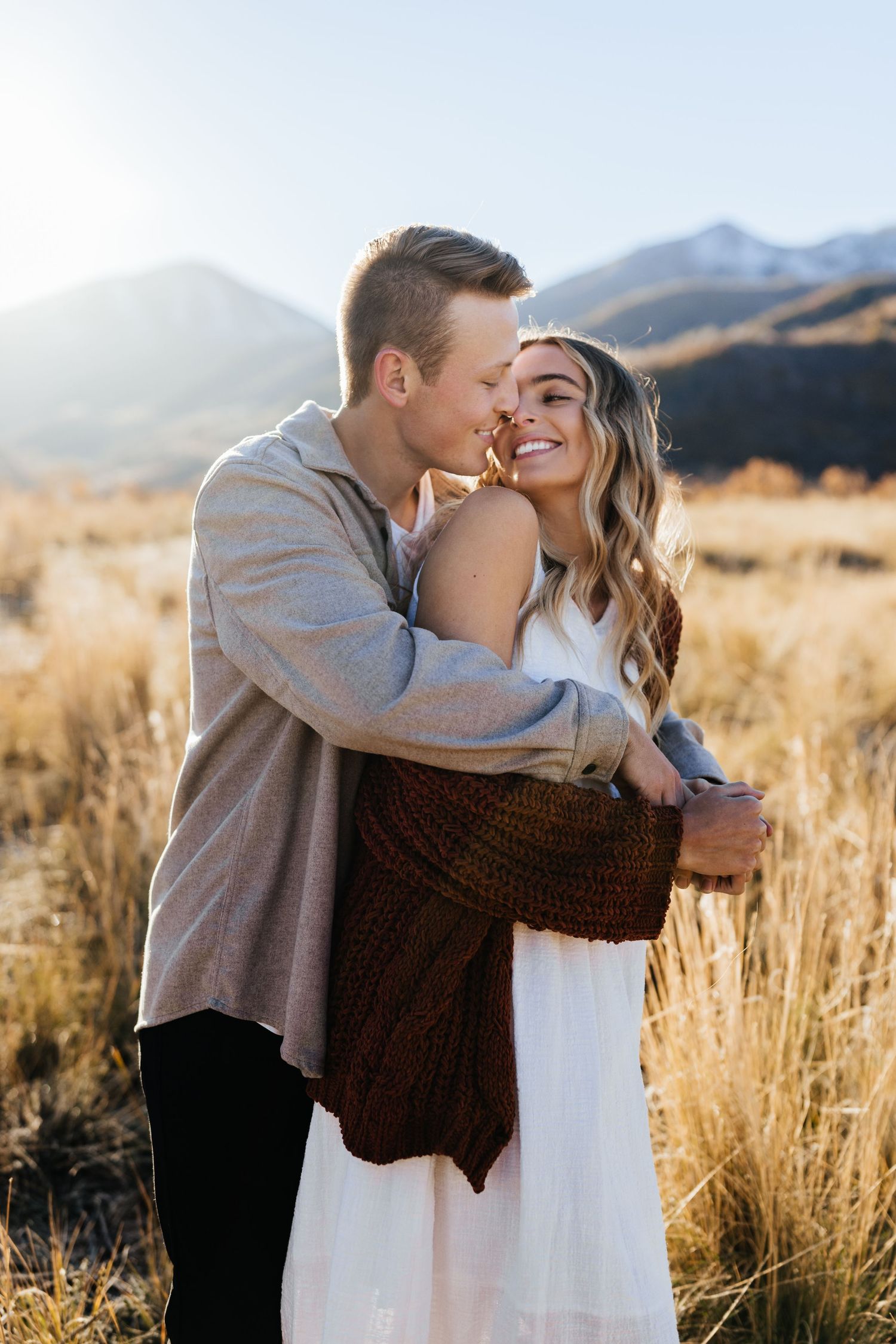 Sunset engagement in Utah mountains during photo session with the couple staring lovingly into each other;s eyes.