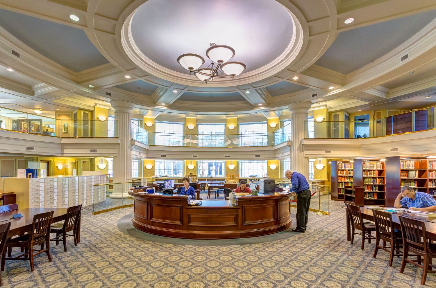Grand circular library with domed ceiling, central desk, and elegant architectural details.