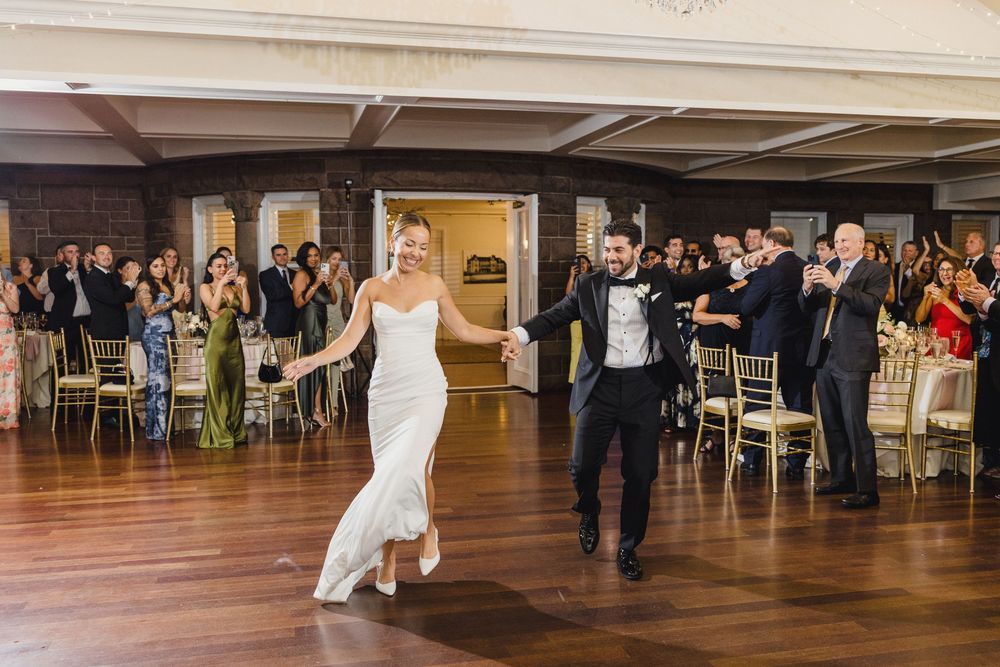 Bride and groom making grand entrance to wedding reception OceanCliff Hotel in Newport, Rhode Island.