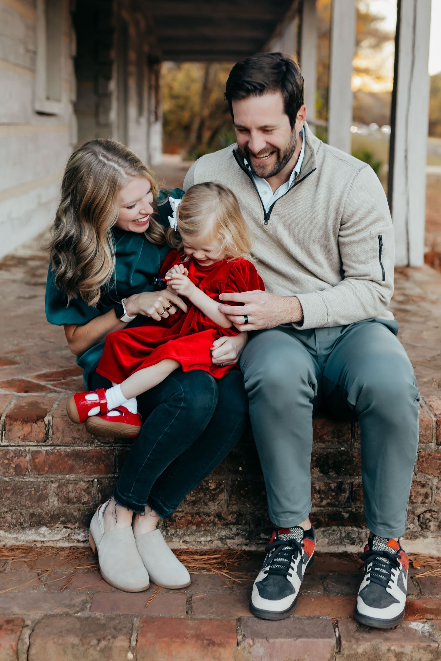 A heartwarming family moment shared on brick steps during a casual outdoor photoshoot.