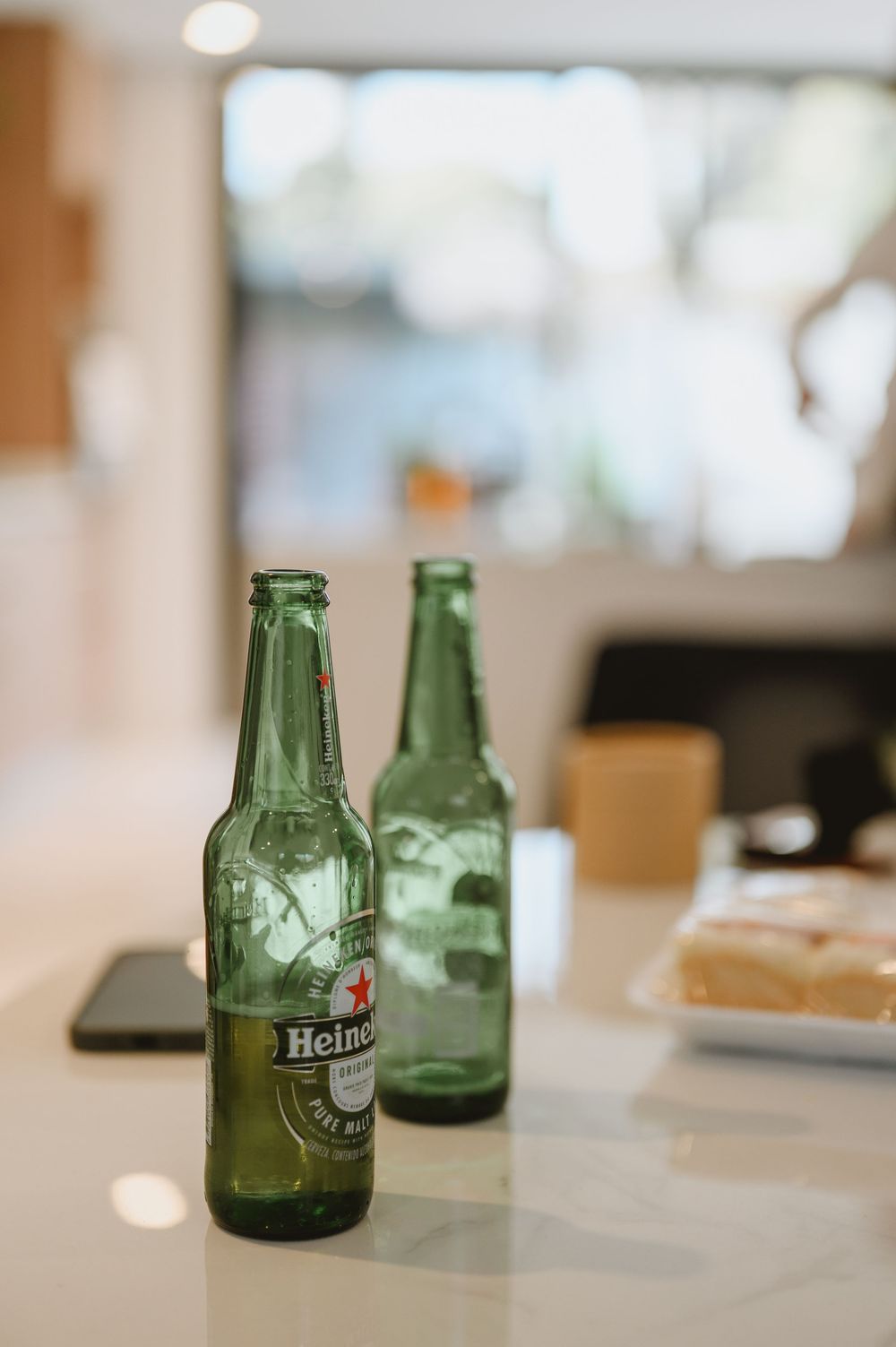Two Heineken beer bottles on white counter during groom wedding preparations getting ready.